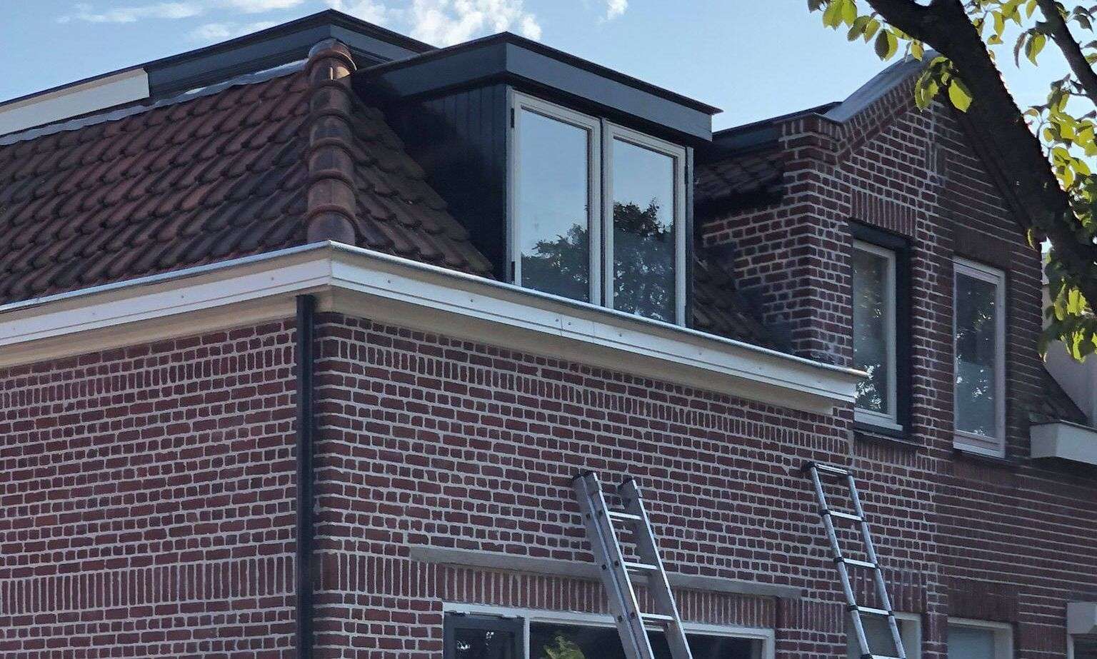 Met de ladden een dakgoot inspecteren in Medemblik